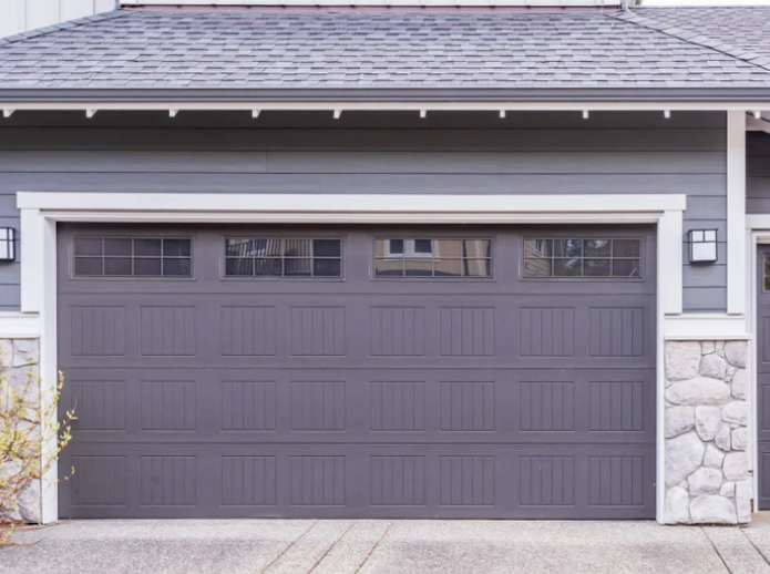 Professional team performing garage door repair in Reynoldsburg, Ohio, using specialized tools to fix a damaged garage door.