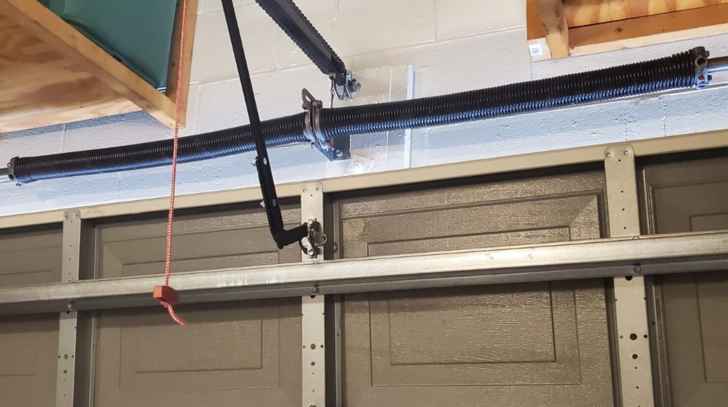 Close-up of a technician performing garage door spring repair in Reynoldsburg, ensuring smooth and safe operation.