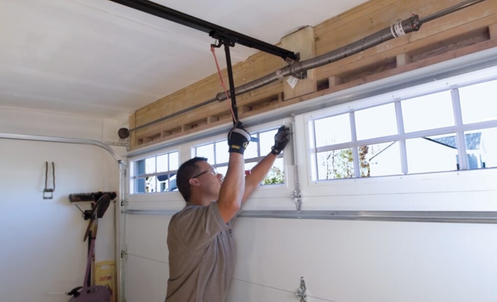 Close-up of a technician performing garage door spring repair in Reynoldsburg, highlighting precise adjustments and tools used in professional garage door maintenance.